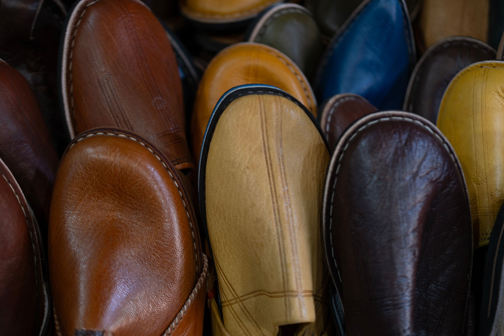 Colorful Vibrant leather handmade Moroccan slippers, babouches for sale in traditional local souk, story heritage and authentic oriental craftsmanship, artisanal culture Morocco